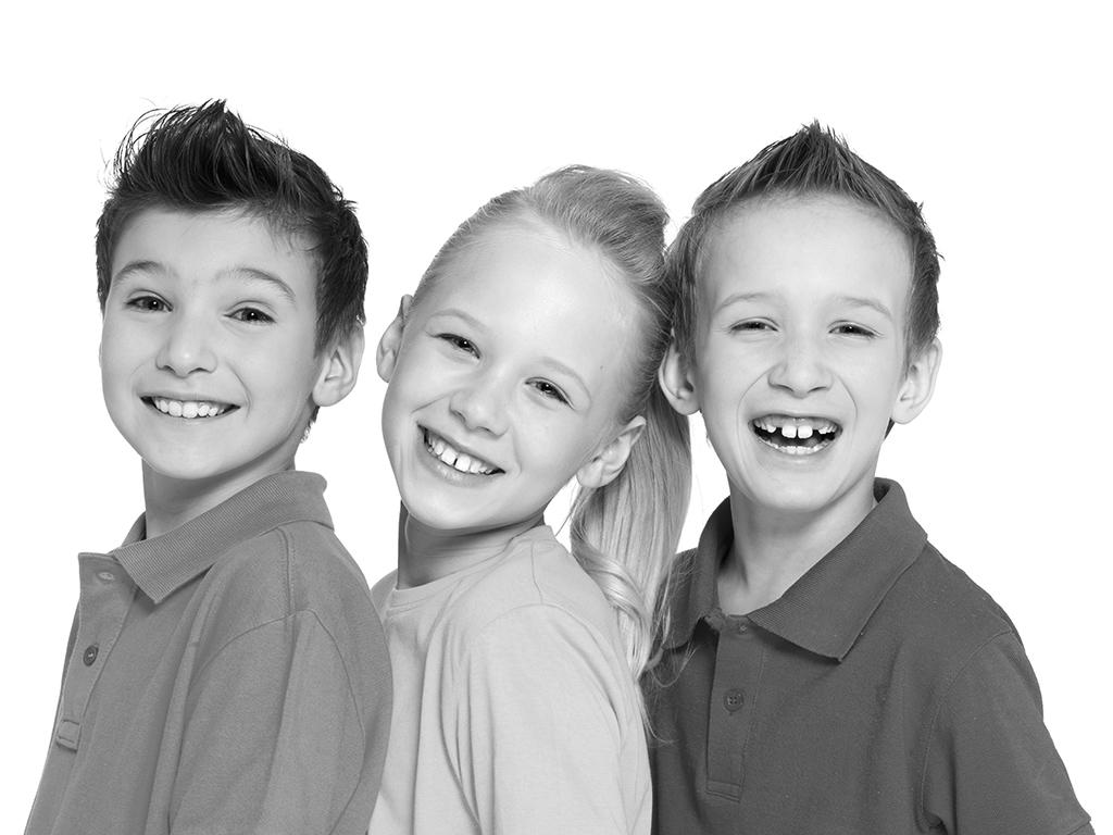 portrait of three happy smiling kids after dental cleanings